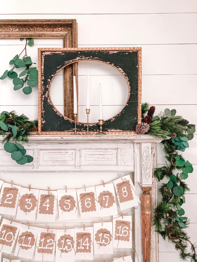 Black and gold frames and garland on faux mantel.
