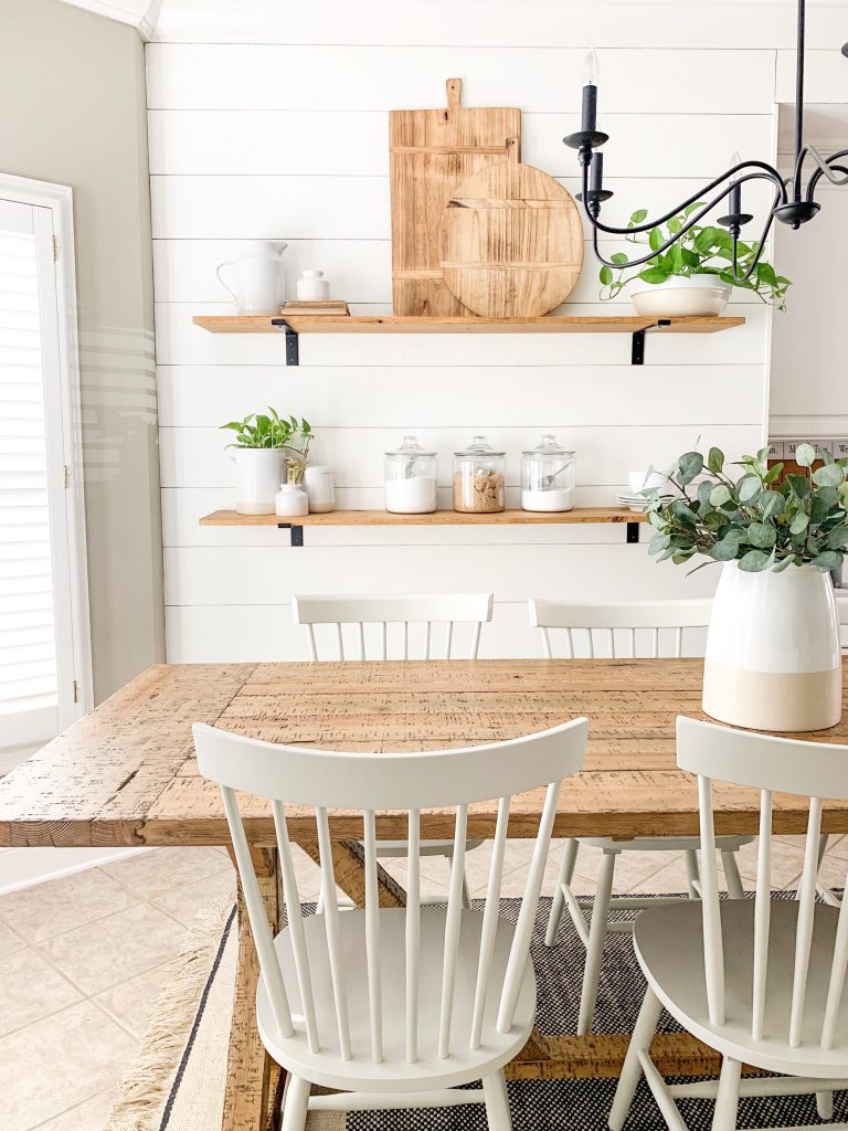 white shiplap wall with wood shelves in kitchen eating nook