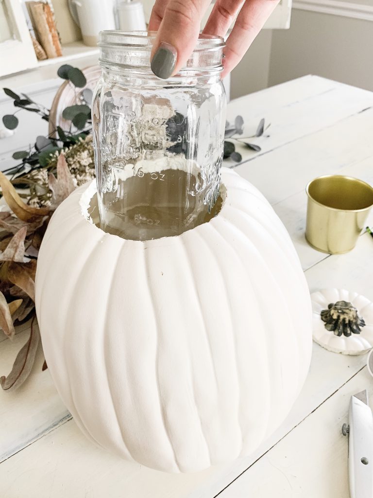 putting mason jar in hole in the top of the pumpkin